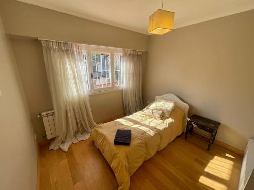 Habitación pequeña con cama y ventana en CASA EN EL BARRIO LOS TRONCOS en Mar del Plata