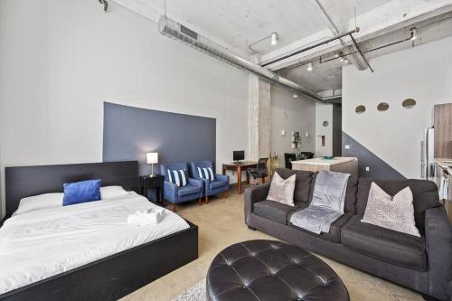 a bedroom with a bed and a couch and a table at Luxurious Downtown Apt / Pool, Laundry, Parking in Dallas