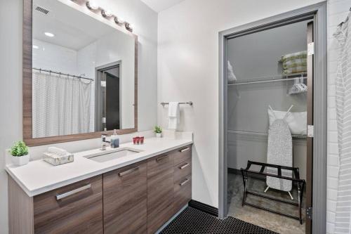 a bathroom with a sink and a mirror at Stunning Downtown Apartment with Pool, Laundry, Parking in Dallas