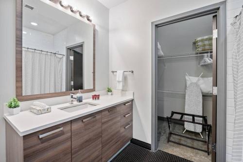 a bathroom with a sink and a mirror at Luxurious Downtown Apt / Pool, Laundry, Parking in Dallas