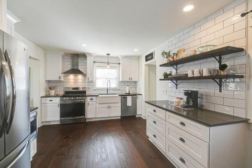 a large kitchen with white appliances and wooden floors at King Suite Highland House of Historic Franklin in Franklin