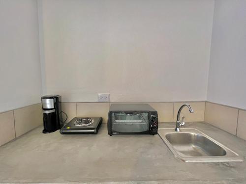 a microwave sitting on a kitchen counter next to a sink at Hotel Citadin Z10 in Guatemala