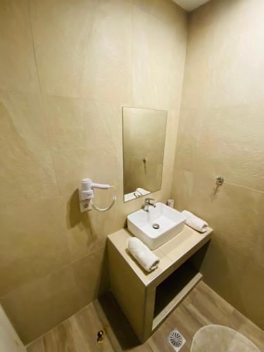 un bagno con lavandino e specchio di Block66 a Città di Rodi