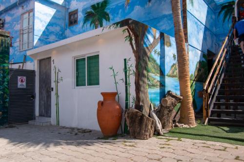 a blue and white building with a vase in front of it at Isla Venados Habitaciones Vacacionales in Mazatlán