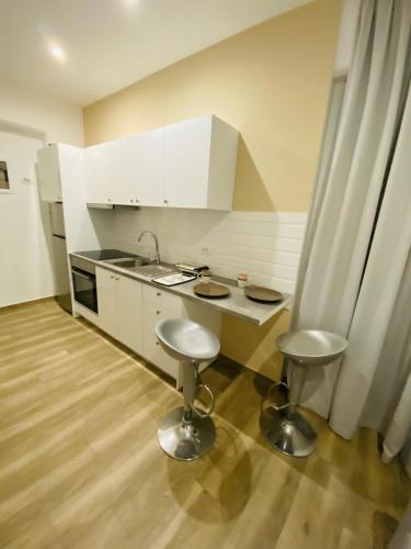 una cucina con lavandino e due sgabelli di Block66 a Città di Rodi