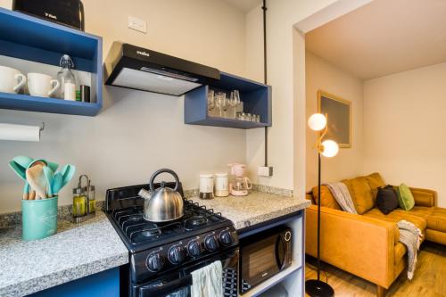 a kitchen with a stove top oven next to a couch at VICENTE SUAREZ By Mr W in Mexico City
