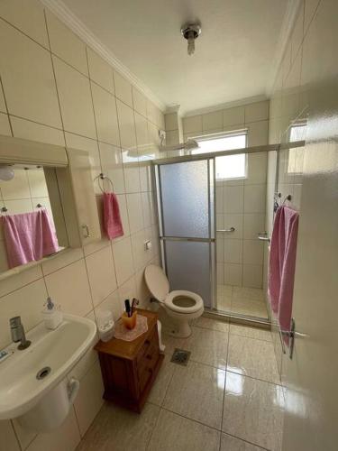 y baño con ducha, aseo y lavamanos. en Apartamento com pé na areia, en São Vicente