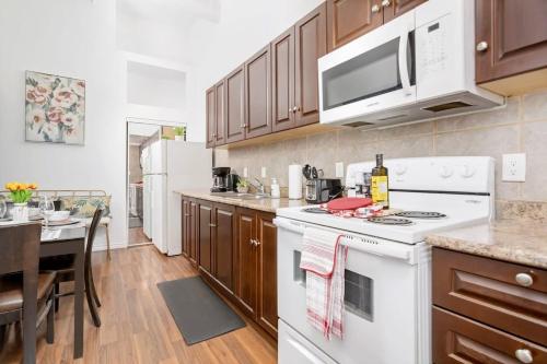 a kitchen with a white stove top oven next to a table at Kensington Market Apartment in Toronto