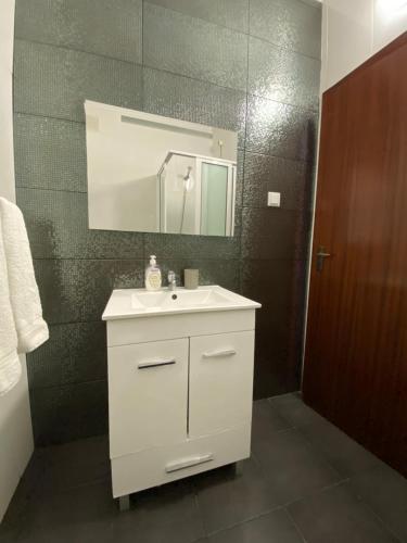 a bathroom with a white sink and a mirror at Inmaculado Apartment in Funchal