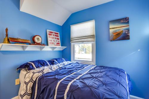 Dormitorio azul con cama y ventana en Greenwood Lake Cottage with Shared Dock and Hot Tub!, en Hewitt