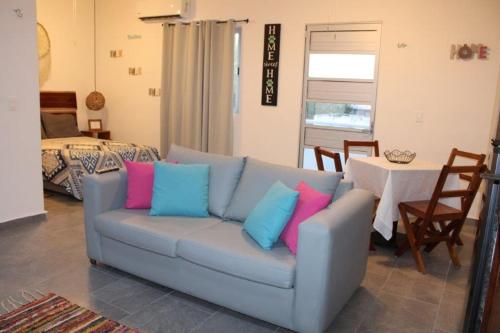 a living room with a blue couch with colorful pillows at Suites Maya Ka’an in Cancún