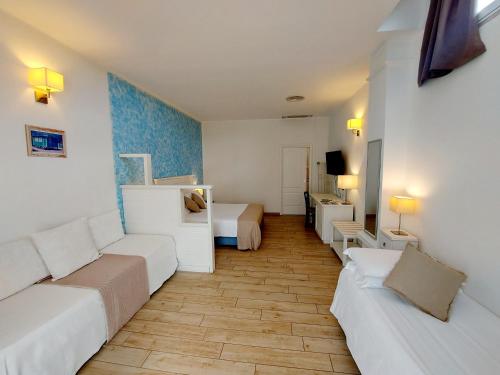 a living room with two beds and a couch at Hotel La Villa Del Mare in Cagliari