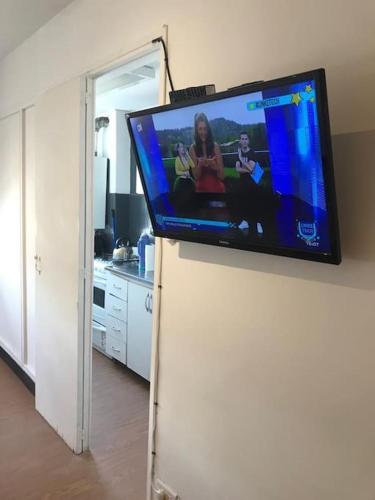 een flatscreen-tv op de top van een koelkast bij Excelente ubicación . in Rosario