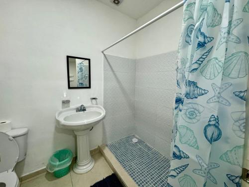 a bathroom with a sink and a shower curtain at Isla Venados Habitaciones Vacacionales in Mazatlán