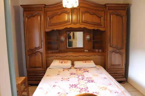 une chambre avec un lit avec une tête de lit en bois dans l'établissement ROCHEL, à Saint-Julien-Boutières