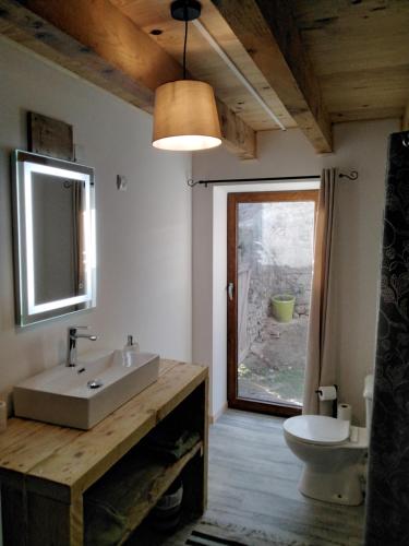 a bathroom with a sink and a mirror and a toilet at Chambres d'hôtes Les cabris in Verneix