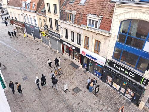 a group of people walking on a street with buildings at T3 en hyper-centre métro à 2 pas in Tourcoing