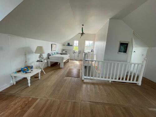 Habitación grande con paredes blancas y suelo de madera. en Bahamian Farm House, en Rock Sound