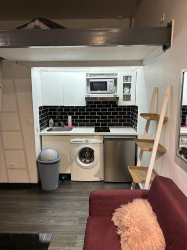 une petite cuisine avec une cuisinière et un micro-ondes dans l'établissement Studio Bastille, à Paris