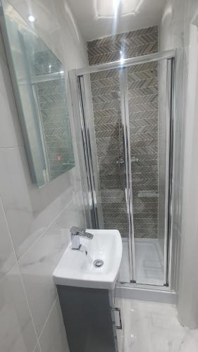 a white bathroom with a shower and a sink at Highfield House in Wellingborough