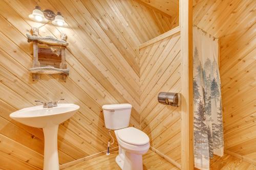 a wooden bathroom with a toilet and a sink at Black River Log Cabin Fish, Swim and Unwind! in Hatfield