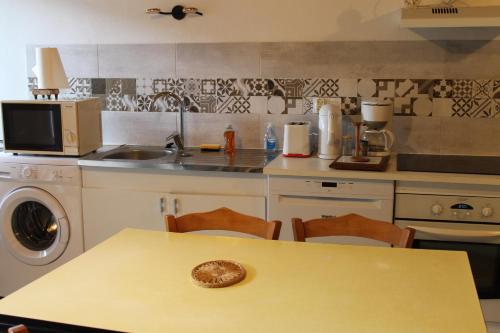 une cuisine avec une table, un évier et une cuisinière dans l'établissement ROCHEL, à Saint-Julien-Boutières