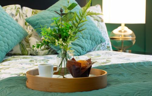 ein Tablett mit Tassen und eine Vase Blumen auf dem Bett in der Unterkunft Entire home in Llanfoist in Abergavenny