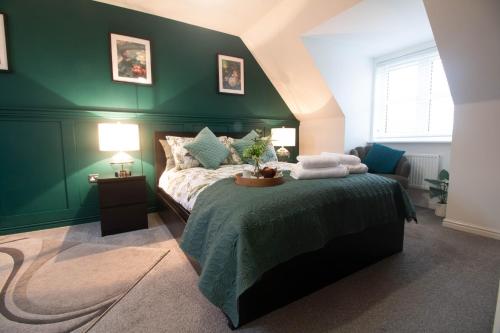 ein grünes Schlafzimmer mit einem Bett mit einer grünen Wand in der Unterkunft Entire home in Llanfoist in Abergavenny