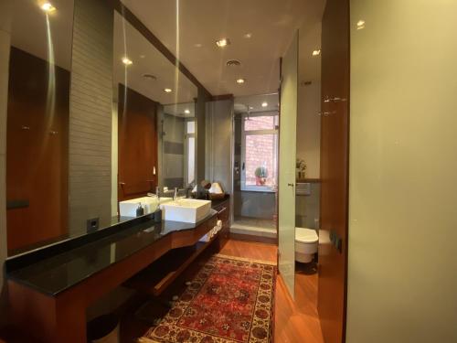 a bathroom with a sink and a toilet and a mirror at Luminous Designer Loft Style Apt Eixample Views By MyRentalHost in Barcelona