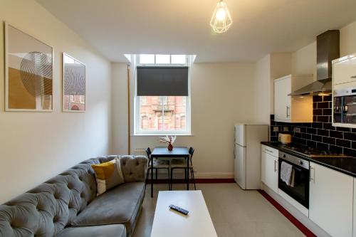 a living room with a couch and a kitchen at Great offers on Long Stays!! LaLuNa Apartments in Gateshead