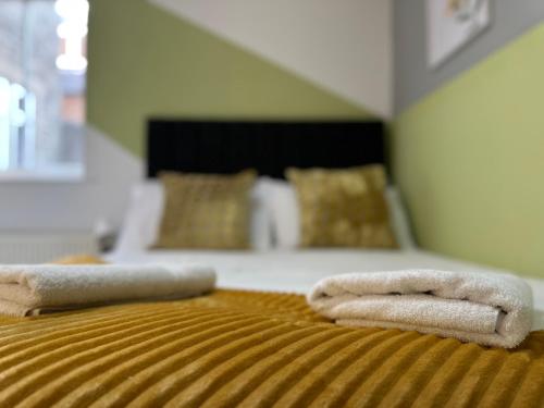 two towels are sitting on top of a bed at Great offers on Long Stays!! LaLuNa Apartments in Gateshead