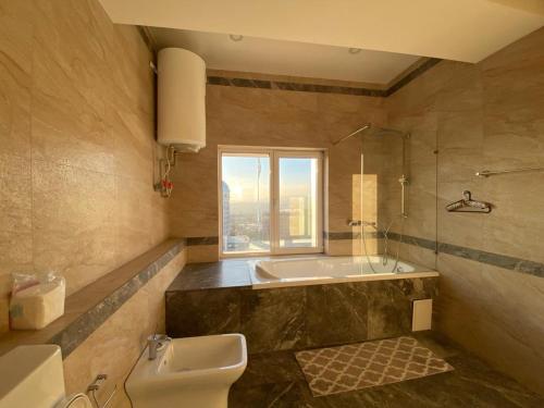 een badkamer met een bad, een toilet en een wastafel bij Sweet home, 4 apartments in Doesjanbe