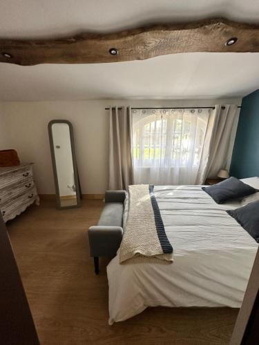 une chambre avec un grand lit et une fenêtre dans l'établissement Au cœur du vignoble cognaçais, à Gondeville