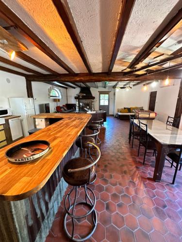 un bar dans un restaurant avec des tables et des chaises dans l'établissement Au cœur du vignoble cognaçais, à Gondeville