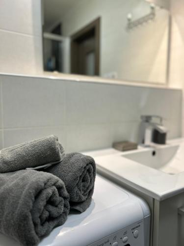 a bathroom with towels sitting on a washing machine at AR LONDON HOUSE in Košice