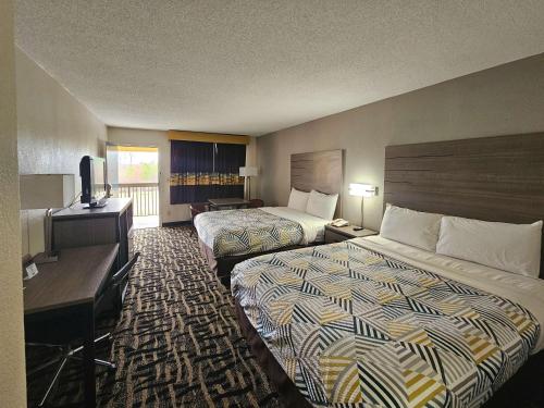 Habitación de hotel con 2 camas y escritorio en Motel 6 Jackson MS Southwest, en Jackson