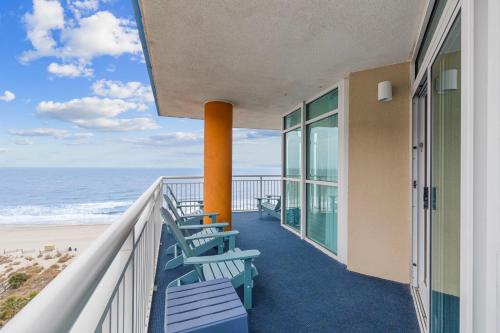 a balcony with blue chairs and the beach at Dunes Village/King bedOceanfront 2b/2b/waterpark in Myrtle Beach