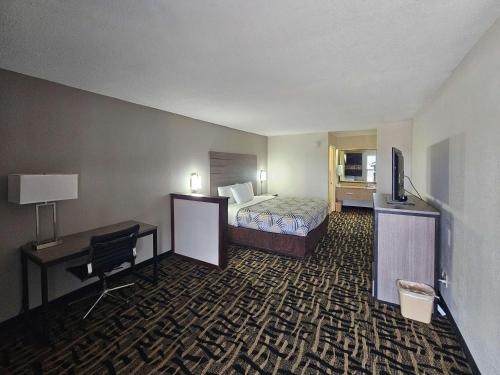 Habitación de hotel con cama, escritorio y ordenador en Motel 6 Jackson MS Southwest, en Jackson