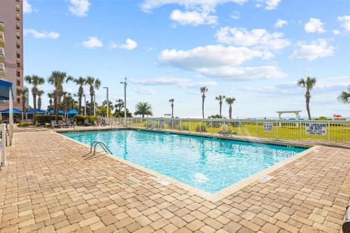 a swimming pool at a resort with palm trees at Dunes Village/King bedOceanfront 2b/2b/waterpark in Myrtle Beach