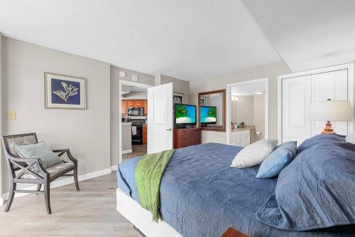 a bedroom with a blue bed and a chair at Dunes Village/King bedOceanfront 2b/2b/waterpark in Myrtle Beach