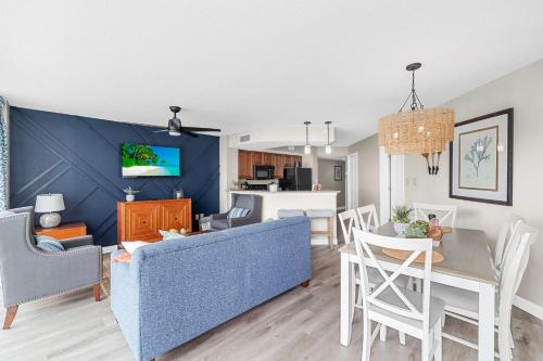 a living room and dining room with a blue accent wall at Dunes Village/King bedOceanfront 2b/2b/waterpark in Myrtle Beach