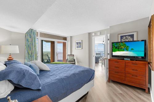 a bedroom with a bed and a flat screen tv at Dunes Village/King bedOceanfront 2b/2b/waterpark in Myrtle Beach