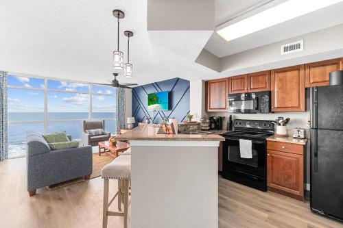 a kitchen and living room with a view of the ocean at Dunes Village/King bedOceanfront 2b/2b/waterpark in Myrtle Beach