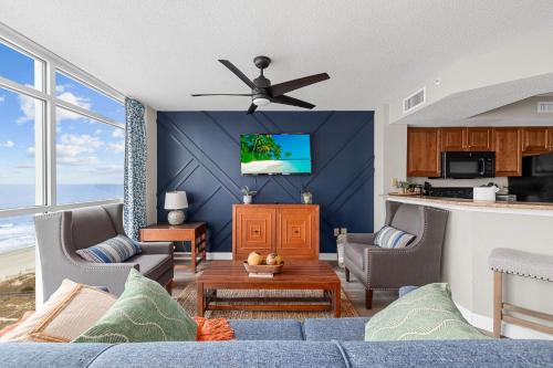 a living room with a blue wall with a ceiling fan at Dunes Village/King bedOceanfront 2b/2b/waterpark in Myrtle Beach