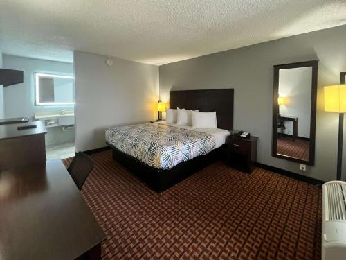 een hotelkamer met een bed en een spiegel bij Motel 6 Chickasha, OK in Chickasha