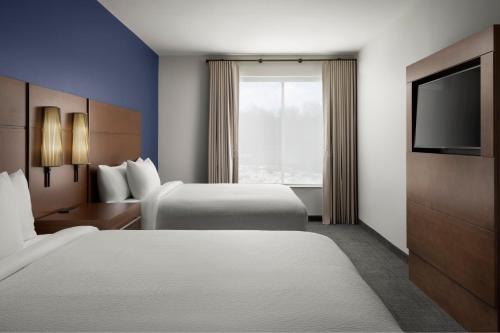 a hotel room with two beds and a flat screen tv at Inn at Bellefield Residence Inn by Marriott in Hyde Park