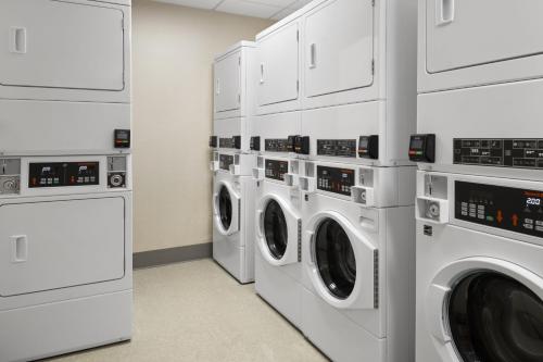 a laundry room with four washer and dryers at Inn at Bellefield Residence Inn by Marriott in Hyde Park