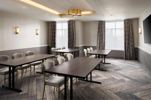 a dining room with tables and chairs and windows at Inn at Bellefield Residence Inn by Marriott in Hyde Park