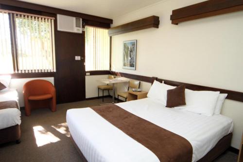 a hotel room with a large bed and a desk at Mildura Golf Resort in Mildura