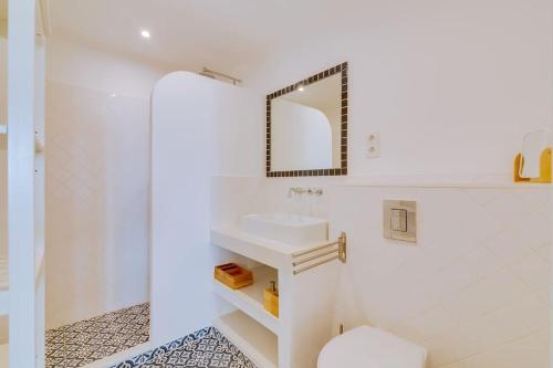 a white bathroom with a sink and a mirror at Casa da Trindade Olhão - Boutique Collection in Olhão